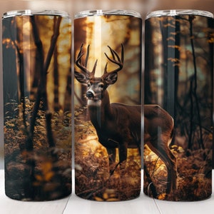 May include: A stainless steel tumbler featuring a brown deer standing in a forest with a sunset in the background.