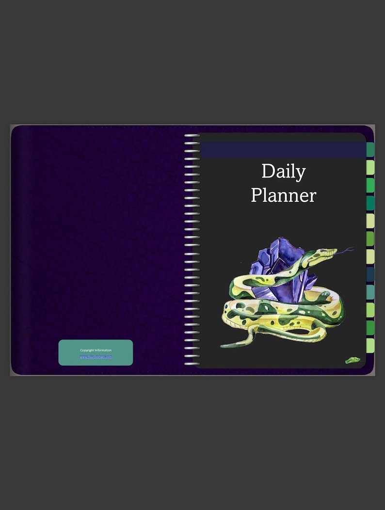 May include: A purple daily planner with a black cover featuring a green snake coiled around a purple crystal. The text "Daily Planner" is printed in white on the cover.