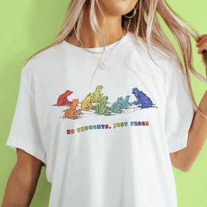 May include: White t-shirt with a rainbow design of frogs and the text "No thoughts, just frogs".