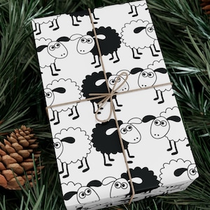 May include: White gift wrap with a black and white sheep pattern. The sheep are cartoon-like and have big eyes. The gift wrap is tied with a brown string.