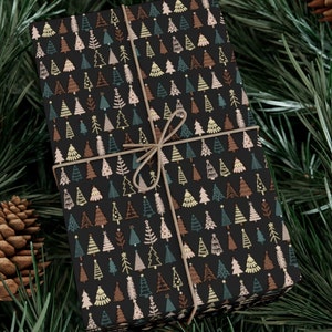 May include: A black gift wrap with a repeating pattern of colorful Christmas trees. The paper is tied with a brown twine bow.