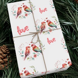 May include: White gift wrap with a repeating pattern of watercolor birds, flowers, and the word "love" in pink.