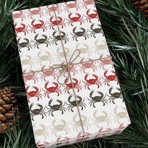 May include: A white gift wrap with a repeating pattern of red, brown, and beige crabs. The gift wrap is tied with a brown twine bow.