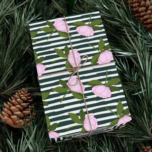 May include: Gift wrap with a repeating pattern of pink peonies on a black and white striped background.