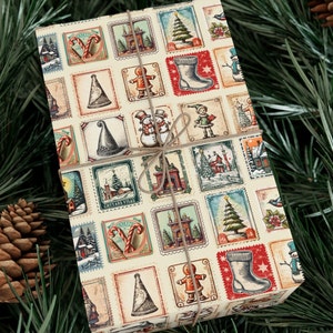 May include: A cream-colored gift wrap with a repeating pattern of vintage-style postage stamps featuring Christmas-themed illustrations. The stamps depict images of candy canes, snowmen, Christmas trees, houses, and other holiday symbols. The paper is tied with a brown twine bow.