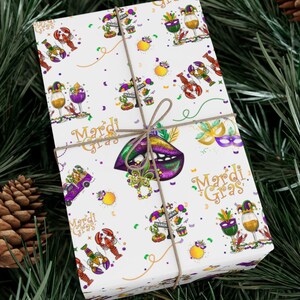 May include: White wrapping paper with a Mardi Gras theme. The paper features a repeating pattern of gold, purple, and green Mardi Gras masks, beads,  lobsters, wine glasses, and the words "Mardi Gras".