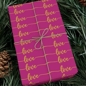 May include: A pink gift wrap with a repeating pattern of the word "love" written in gold cursive.