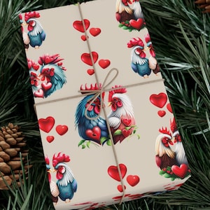 May include: A beige gift wrap with a repeating pattern of red hearts and a pair of roosters in love. The roosters are blue, red, and white with a detailed illustration style. The gift wrap is tied with a brown twine bow.