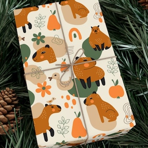 May include: A white gift wrap with a repeating pattern of brown capybaras, pears, flowers, and abstract shapes in shades of orange, green, and brown. The paper is tied with a brown twine bow.