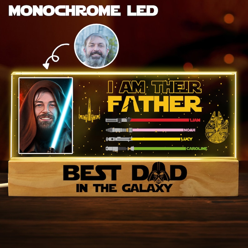 K&ouml;nnte beinhalten: Ein Holzsockel mit einer leuchtenden Acrylplatte mit einem Star Wars-Motiv. Die Platte zeigt eine Figur aus Star Wars, ein Raumschiff und Lichtschwerter. Der Text "Ich bin ihr Vater" und "Bester Papa der Galaxie" ist auf der Platte zu sehen. Ein Foto eines Mannes befindet sich in der oberen linken Ecke des Bildes.