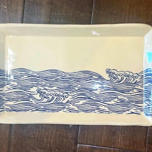 May include: A set of three ceramic mugs with a speckled, matte finish. Each mug features a different color: light blue, cream, and gray. The mugs have a simple, modern design and a comfortable handle.