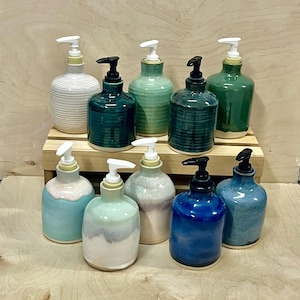 Pu&ograve; includere: Una collezione di nove dispenser per sapone in ceramica in vari colori, tra cui bianco, verde acqua, verde chiaro, verde scuro, blu e smalti pastello multicolori. Ogni dispenser presenta un meccanismo a pompa bianco o nero, con texture lisce o a coste.