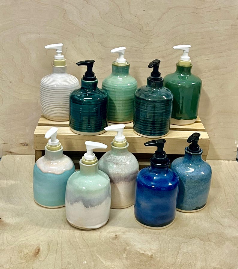 Pu&ograve; includere: Una collezione di nove dispenser per sapone in ceramica in vari colori, tra cui bianco, verde acqua, verde chiaro, verde scuro, blu e smalti pastello multicolori. Ogni dispenser presenta un meccanismo a pompa bianco o nero, con texture lisce o a coste.