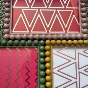 May include: Three picture frames with different geometric patterns. The top frame is pink with white triangles, the left frame is green with pink zigzags, and the right frame is yellow with white triangles.