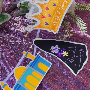 Puede incluir: Una pancarta de papel colorida con una corona dorada, una mezquita azul y amarilla, un triángulo negro con texto árabe y una mariposa morada. La pancarta dice "Peak of Glory".