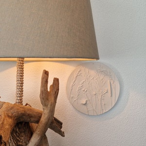 Round frame in plaster with floral reliefs