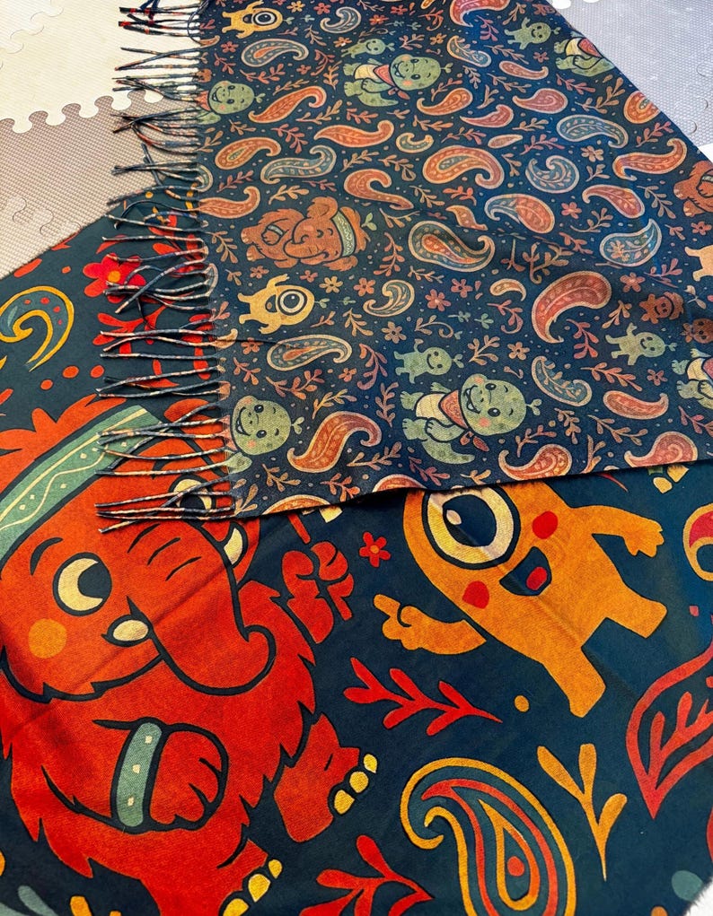 May include: A colorful scarf with a dark blue background and a repeating pattern of paisley shapes, cartoon characters, and floral elements. The scarf has a fringed edge and features red, orange, and green designs.