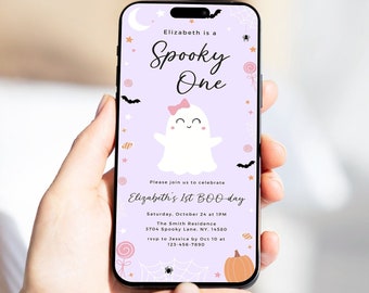 May include: A smartphone displays a Halloween-themed invitation. The invitation features a cute ghost with a pink bow, the text "Spooky One," and event details. The background is light purple with bats, stars, and a pumpkin.