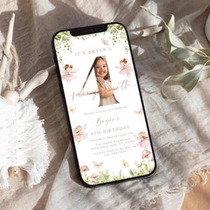May include: A digital invitation for a 4th birthday party with a fairy theme. The invitation features a photo of a girl in a pink dress with a pink number 4 and the words "It's Bryer's Fairy 4th Birthday". The invitation also includes a floral design with butterflies and mushrooms.
