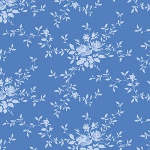 Pode incluir: Um tecido azul com um padrão repetitivo de rosas azul-claras e ramos delicados. Uma régua vertical é visível no lado esquerdo, mostrando uma escala de medição em polegadas que indica o tamanho do padrão deste material têxtil.