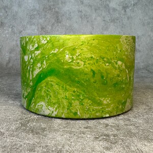 May include: A green and white marbled ceramic planter with a smooth, rounded shape. The planter has a light green base with white swirls and streaks throughout.