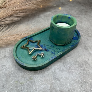 May include: An oval tray in green and blue with a star-shaped hair clip, two small earrings, and a teal green and blue hexagonal candle holder.