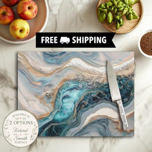 May include: A rectangular cutting board featuring a swirling abstract pattern of blue, teal, white, and gold tones. A stainless steel chef knife with a silver handle rests on the surface. The board displays a marbled design with metallic accents.
