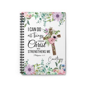 May include: A white spiral notebook with a floral design and the quote "I can do all things through Christ who strengthens me" with the scripture reference Philippians 4:13. The name Courtney is written at the bottom of the notebook.