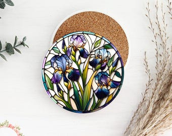 Può includere: Un sottobicchiere rotondo in ceramica con un design a vetri colorati di fiori di iris viola, blu e gialli. Il sottobicchiere è su una superficie bianca.