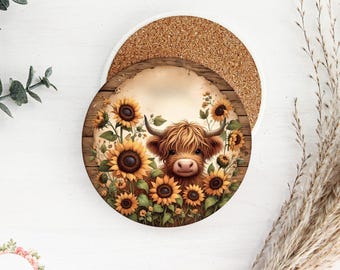 May include: A round wooden coaster with a brown background and a cute cartoon Highland cow with brown fur and a white face surrounded by yellow sunflowers.