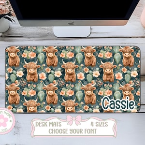 May include: A rectangular desk mat featuring a repeating pattern of watercolor Highland cows, cacti, and flowers in shades of brown, green, and peach on a teal background. The name "Cassie" is printed on the mat. The mat has a decorative border with text.