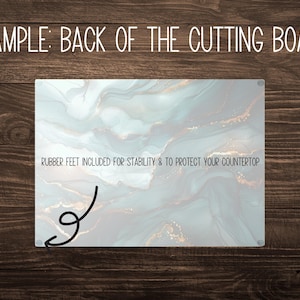 May include: A rectangular cutting board with a marbled design in shades of blue, gray, and gold. The text "RUBBER FEET INCLUDED FOR STABILITY & TO PROTECT YOUR COUNTERTOP" is printed on the board.