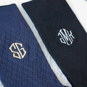 Puede incluir: Dos pares de calcetines azul oscuro con iniciales bordadas. Un par tiene las iniciales "SG" en hilo dorado y el otro par tiene las iniciales "JMK" en hilo blanco.
