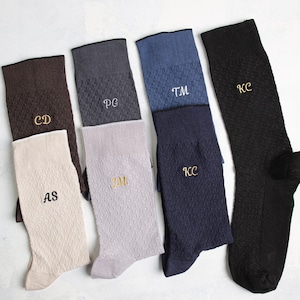 Puede incluir: Seis pares de calcetines con diferentes iniciales bordadas. Los calcetines son de diferentes colores, incluyendo marr&oacute;n, gris, azul y negro.