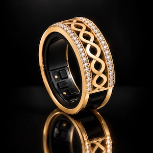 Peut inclure: Une bague dorée présentant une bande centrale avec un motif de nœud infini ajouré, encadrée par deux rangées de petites pierres claires. L'intérieur de la bague est noir avec des capteurs électroniques et des points de contact visibles.