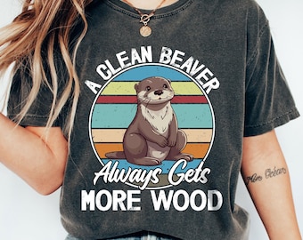 May include: A gray t-shirt with a vintage-style graphic of a beaver with the text "A Clean Beaver Always Gets More Wood".