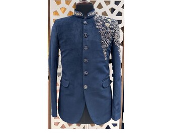 Puede incluir: Chaqueta azul marino con cuello mandarín y bordados ornamentados en el hombro. La chaqueta tiene una botonadura frontal y dos bolsillos delanteros. El bordado presenta hilos dorados y plateados en un diseño floral. La chaqueta se exhibe en un maniquí.
