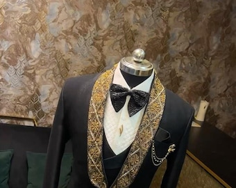 May include: A black tuxedo jacket with a gold beaded trim around the collar and a black bow tie. The jacket is on a mannequin and has a pocket on the left side.