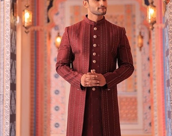 May include: A maroon long-sleeved jacket with a mandarin collar and silver buttons. The jacket has a subtle pattern of small silver sequins.