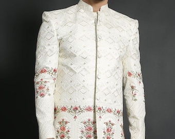 May include: A white long-sleeved jacket with a mandarin collar and a button closure. The jacket has a geometric pattern and is embroidered with pink and green flowers.