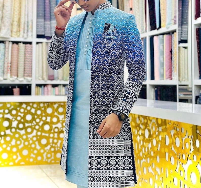 May include: A blue and black patterned long-sleeved jacket with a light blue inner lining. The jacket has a mandarin collar and a button closure.