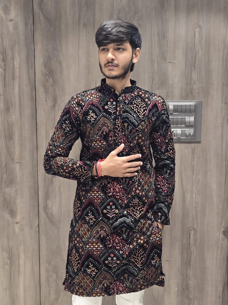 May include: A black long-sleeved kurta with a red, gold, and silver patterned design. The kurta has a mandarin collar and a button closure.