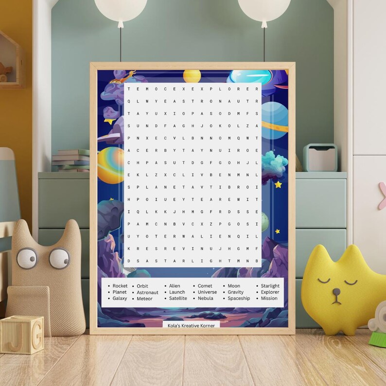 以下が含まれることがあります： 青と紫の背景に、宇宙をテーマにした単語検索パズルが額装されています。「ロケット」、「惑星」、「宇宙飛行士」などの単語が含まれています。フレームの下部には「Kola's Kreative Korner」と書かれています。