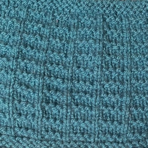 May include: Close-up of a teal blue knitted fabric with a textured pattern.