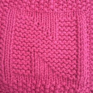 Könnte beinhalten: Eine Nahaufnahme eines pinkfarbenen gestrickten Stoffes mit einem strukturierten Muster. Der Stoff ist aus Garn gefertigt und hat eine weiche, flauschige Textur.