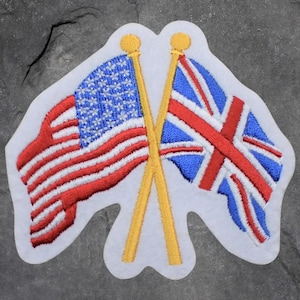 May include: Embroidered patch depicting the American and British flags crossed. The American flag shows red and white stripes with a blue field of white stars. The Union Jack has red and white stripes on a blue background. The flags are on yellow poles.