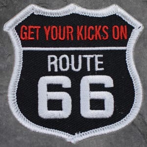 May include: Embroidered patch with a black background and a white border. The patch features the text "GET YOUR KICKS ON" in red, "ROUTE" in white, and the number "66" in white.