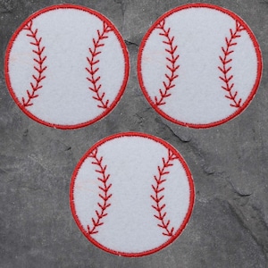 May include: Three circular baseball patches, each with a white base, red stitching, and a red border, are displayed on a grey surface. These patches are ideal for sports-themed crafts or apparel decoration.