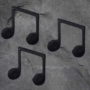 May include: Four black musical note symbols are arranged on a grey, textured background. The notes have a textured appearance, and the background has a weathered, stone-like texture. The image has a monochromatic colour scheme.