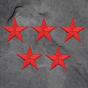 May include: Five red embroidered star patches. The stars are five-pointed and have a slightly raised texture.